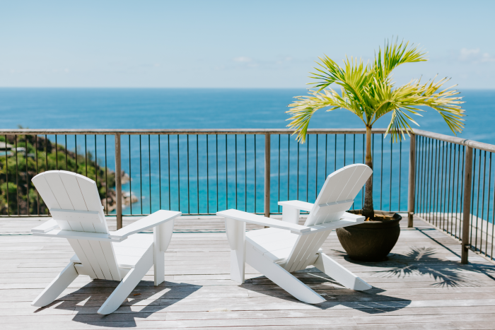 A Balcony with an Ocean View Containing a Potted Plant and Two Chairs