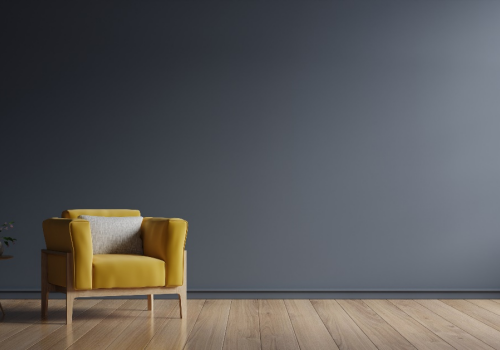 A yellow armchair next to dark-colored wall