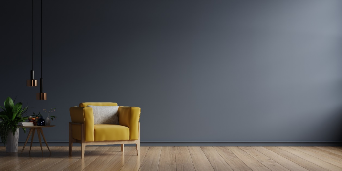 A yellow armchair next to dark-colored wall